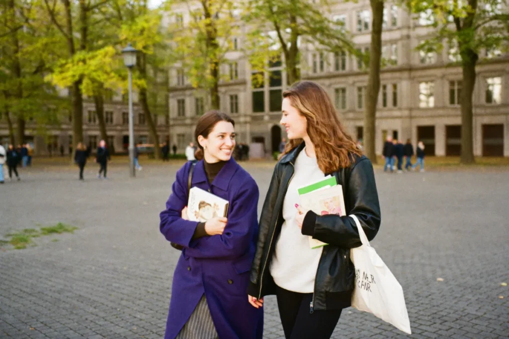 Zwei Studentinnen auf dem Campus im Herbst